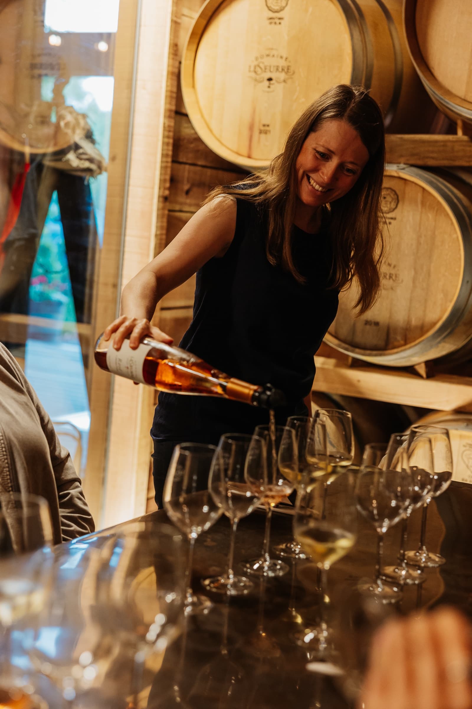 Céline LeSeurre pouring rosé across a line of tasting glasses.