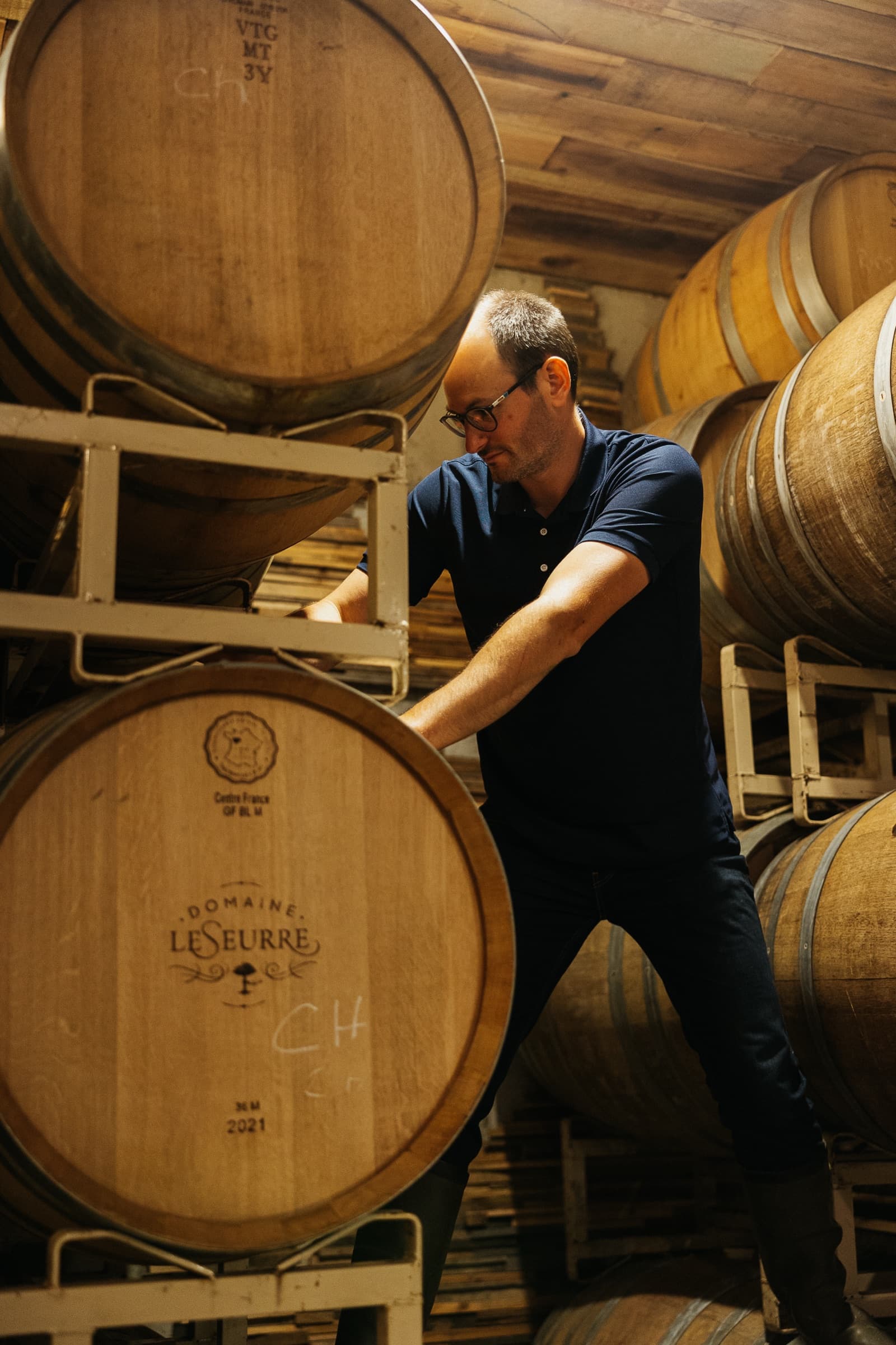 Sébastien LeSeurre moving oak barrels in the cellar.
